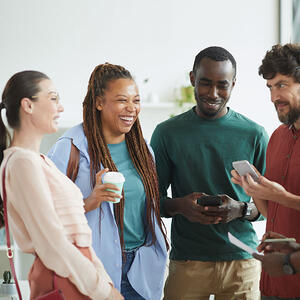 Group of people chatting, smiling and looking at cell phones